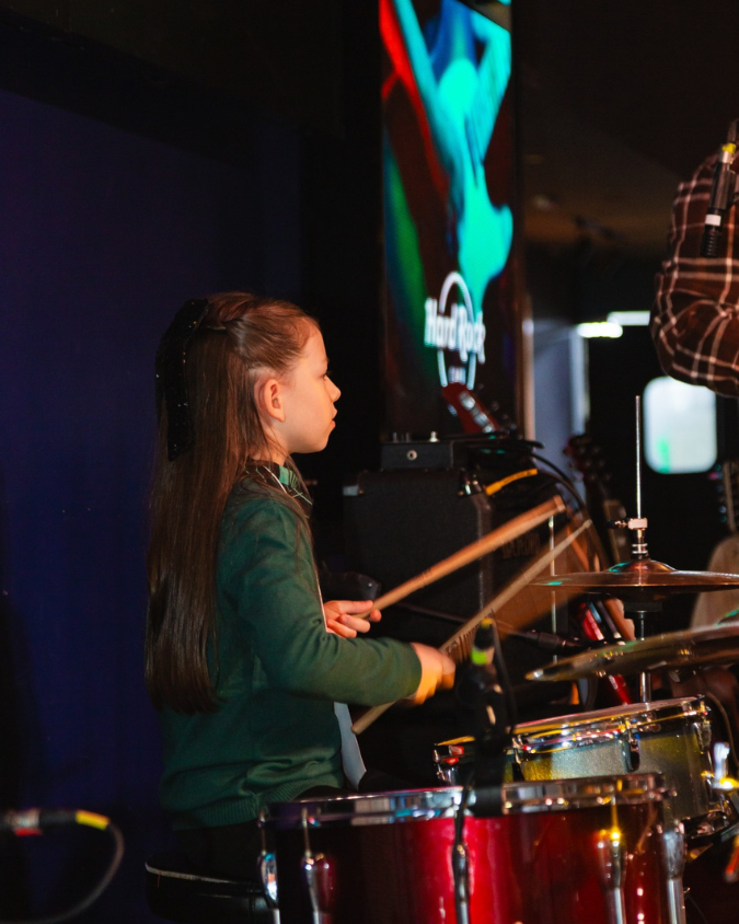 Professor e aluno em aula individual de bateria.