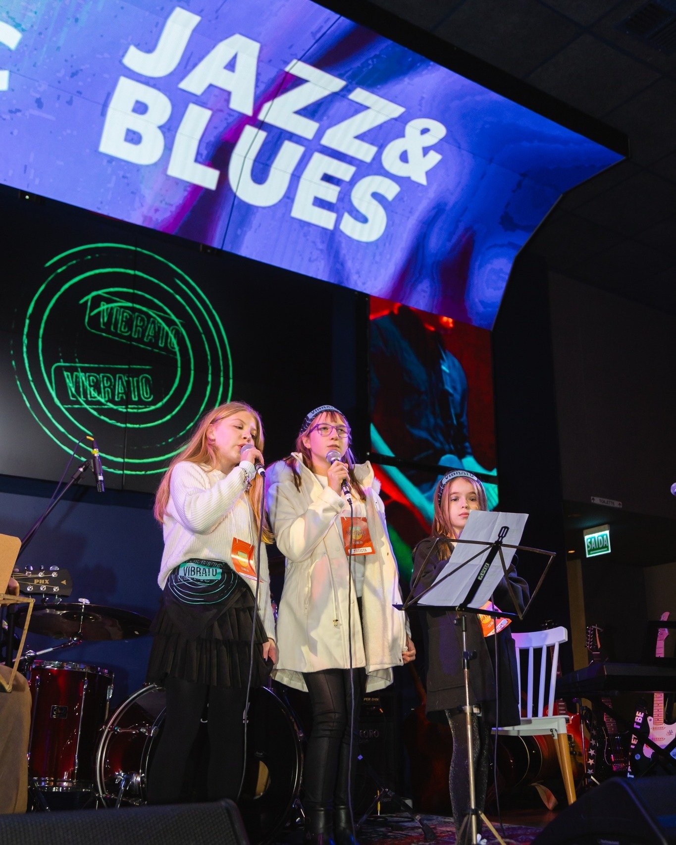 Aluna de canto na Vibrato Porto Alegre – aquecimento vocal no microfone.