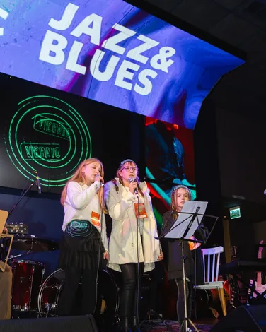 Aluna de canto na Vibrato Porto Alegre – aquecimento vocal no microfone.