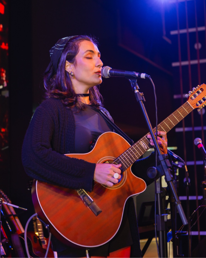 Sarau da Vibrato – performance vocal com violão no palco.
