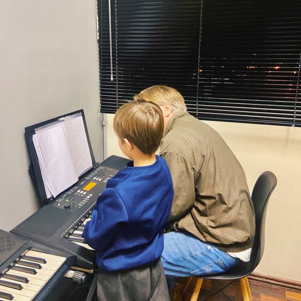 Professor orientando aluno no piano – leitura e repertório.