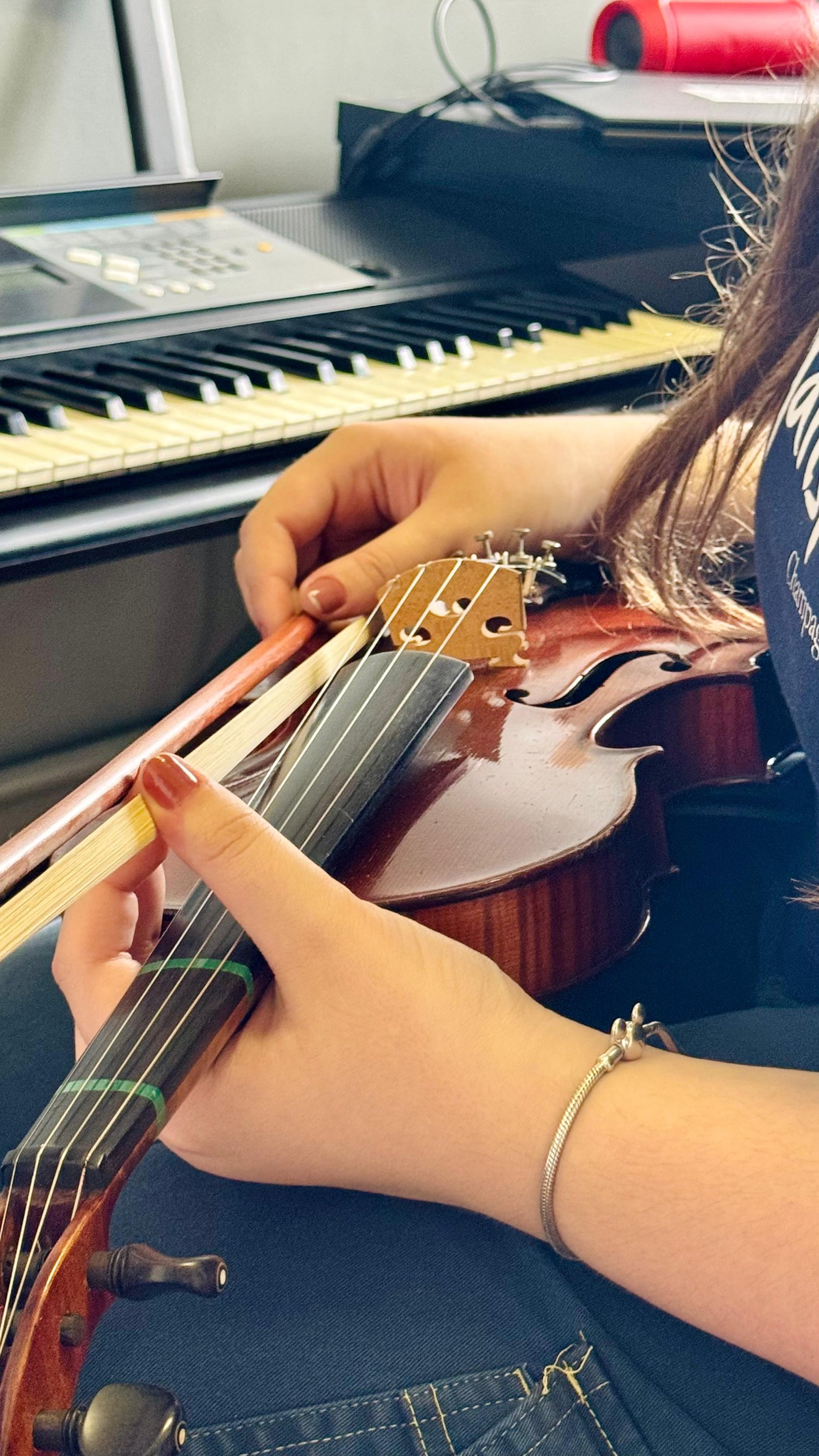 Close-up das mãos afinando o violino. Técnica de afinação e postura do arco na Vibrato (PUCRS), Porto Alegre.