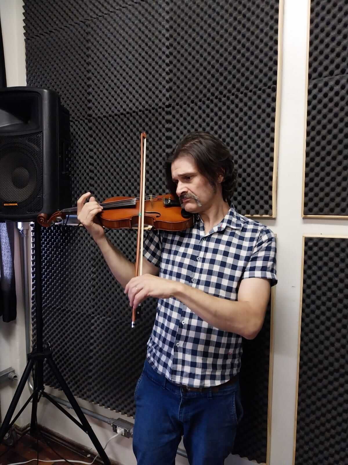 Prática de violino ao lado de monitor de áudio e estudo de dinâmica e articulação na Vibrato, Porto Alegre.