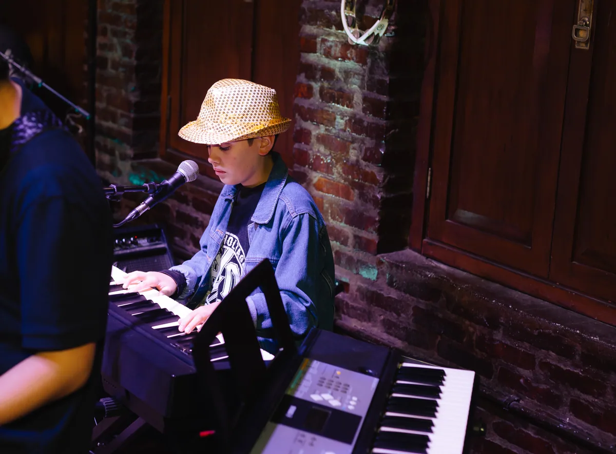 Aluno tocando piano digital em apresentação da Vibrato em Porto Alegre