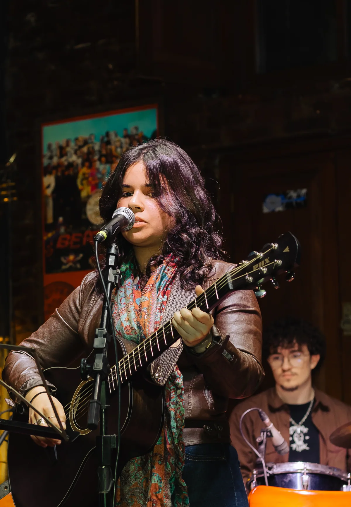 Aluna tocando violão em apresentação da Vibrato em Porto Alegre