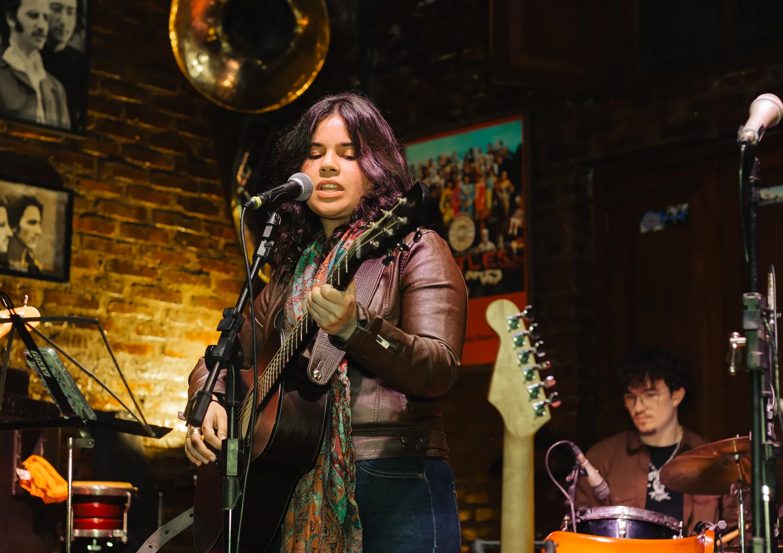 Cantora tocando violão durante o sarau da Vibrato em Porto Alegre